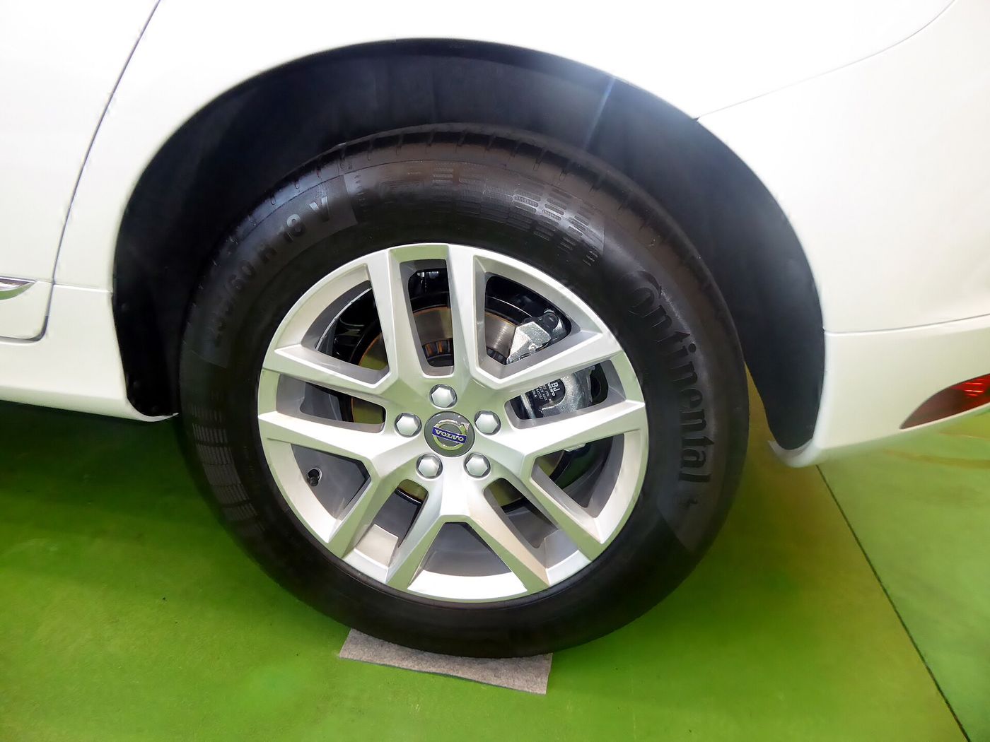 A clean alloy wheel and tyre under a white wheel arch